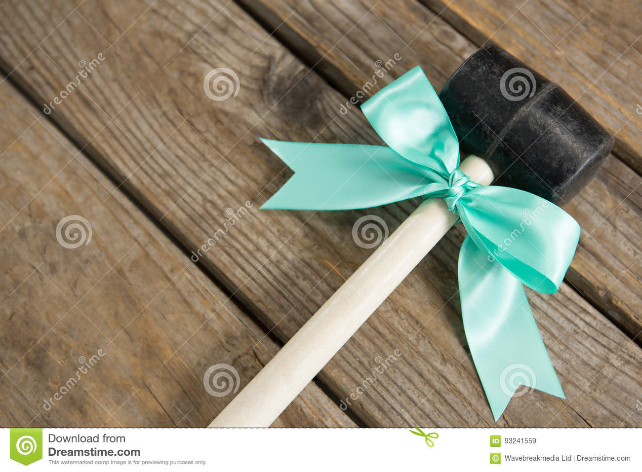 close-up-hammer-ribbon-bow-wooden-table-93241559.jpg