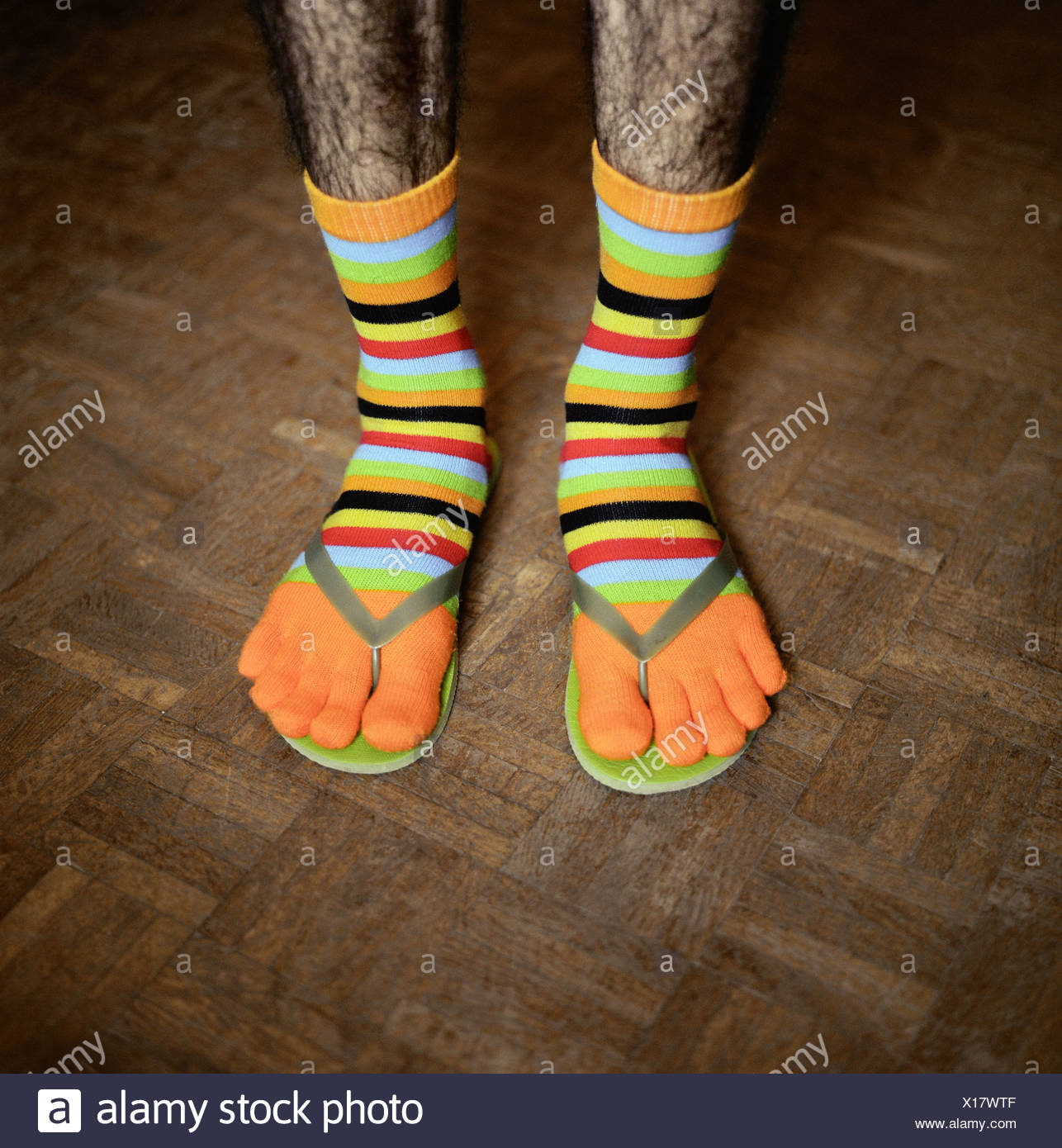 low-section-view-of-a-man-wearing-funny-socks-and-flip-flops-X17WTF.jpg